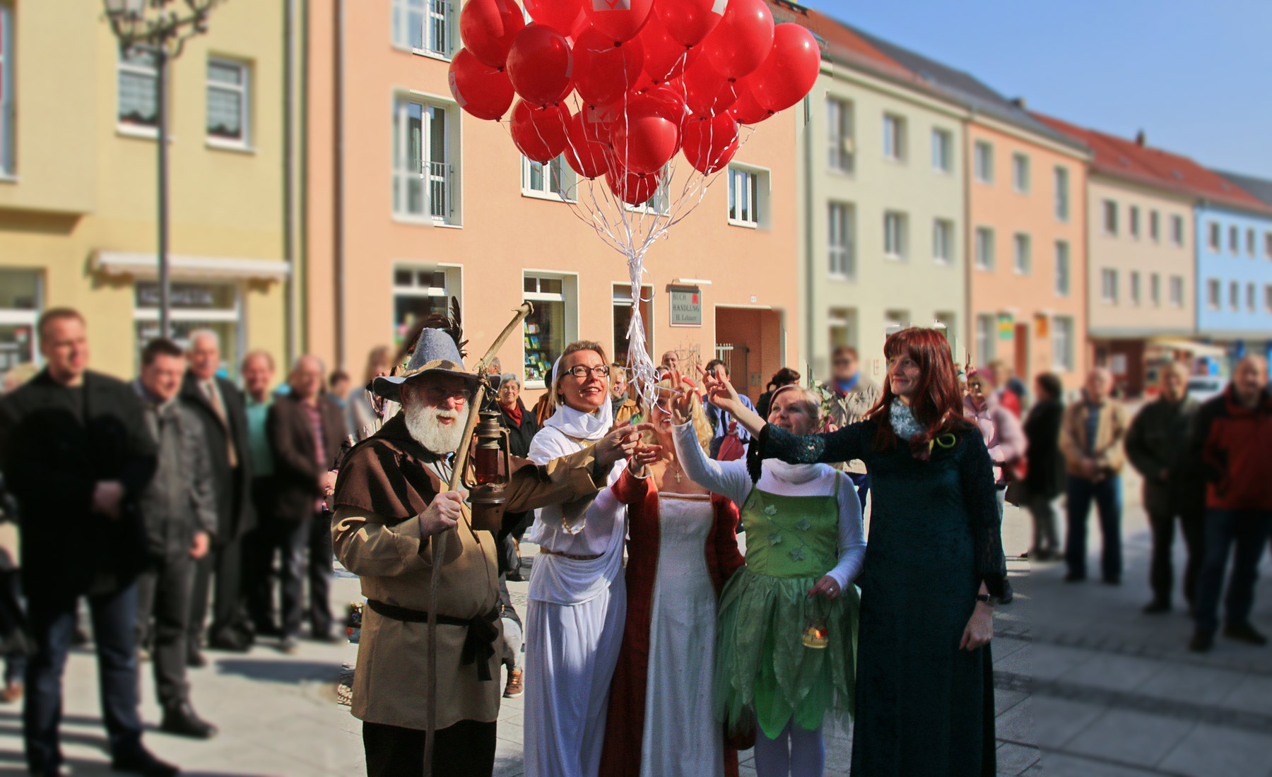 Feststimmung, historisch verkleidete Personen mit roten Luftballons